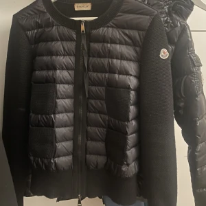 Moncler Cardigan - Säljer min svarta moncler cardigan då den inte används 🖤Den är i fint skick och i storlek L men är liten i storlek så passar nån i s/m 🖤Äktighetsbevis finns samt fler bilder 
