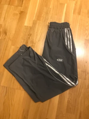 Vintage track pants - Ett par vintage track byxor med adidas kända tre sträck på sidan dom har en rätt baggy passform och passar vem som helst i midjan då den är anpassbar. Skriv om du har mer frågor.