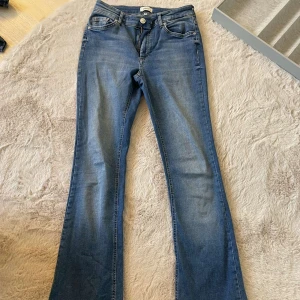 Blåa bootcut jeans - Säljer dessa jeans från Only eftersom att de är inte min stil längre. Jeansen är i mycket bra skick. De är storlek 32 men är väldigt stretchiga så skulle säga 34. 
