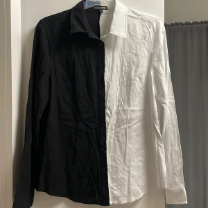 Skjorta - Svart/vit - Skjorta från FashionNova, storlek S (passar både för XS och M också). Mycket efterfrågad plagg, då man kan style den jättebra! Helt ny i skick, bara använd 1 gång. 