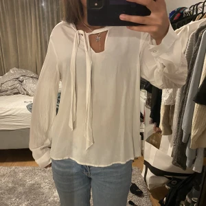 Vit blus  - Vit blus från Stockhol LM som man antingen kan knyta eller låta hänga!🤍