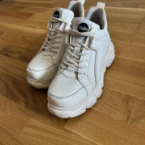 Buffalos - Vita buffalos i storlek 38. De är använda och har ett litet svart  märke bak som inte går bort men annars fina. 450+eventuell frakt eller bud