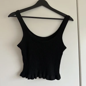 Zara topp! - Svart topp ifrån Zara, med en liten volang nertill!