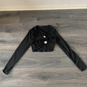 Svart topp  - Svart långärmad topp med dekorativa stenar från Nelly. Strl S.
