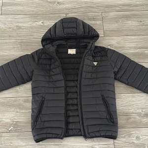 Guess dunjacka - En skit snygg guess dunjacka som aldrig är använd. Den är tunn och perfekt till vår/höst. Storleken motsvarar XS i vuxensize men är perfekt till barn med size L också. Kan mötas upp eller frakta.