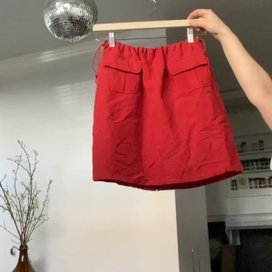 Cute 90s kjol - 90-tals kjol i en ”sommarröd”, som en lite urtvättad röd. Köpt secondhand och så snygg men aldrig kommit till användning :c finns en liten slits baktill. Dragband i midjan så passar xs-m, kanske tom l. 