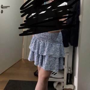En till volang kjol som är blå med blommor på🌸tror storleken är Xs💞