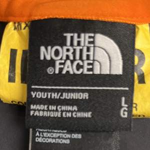 En orange The North Face jacka som går och vända ut och in för att få den svart   Ordinarie pris: 1400kr