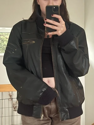 Vintage läderjacka!! - En vintage läderjacka köpt på second hand. Den kommer tyvärr inte till användning längre. Den har as coola detaljer! Riktigt läder också! Det står att den är från Outfit Leatherwear. Storleken är L<33