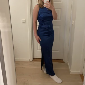Balklänning - Jag säljer denna fina marinblåa klänningen med one shoulde. (Klänningen är helt ny och oanvänd) Den är i petite modell och storlek 36