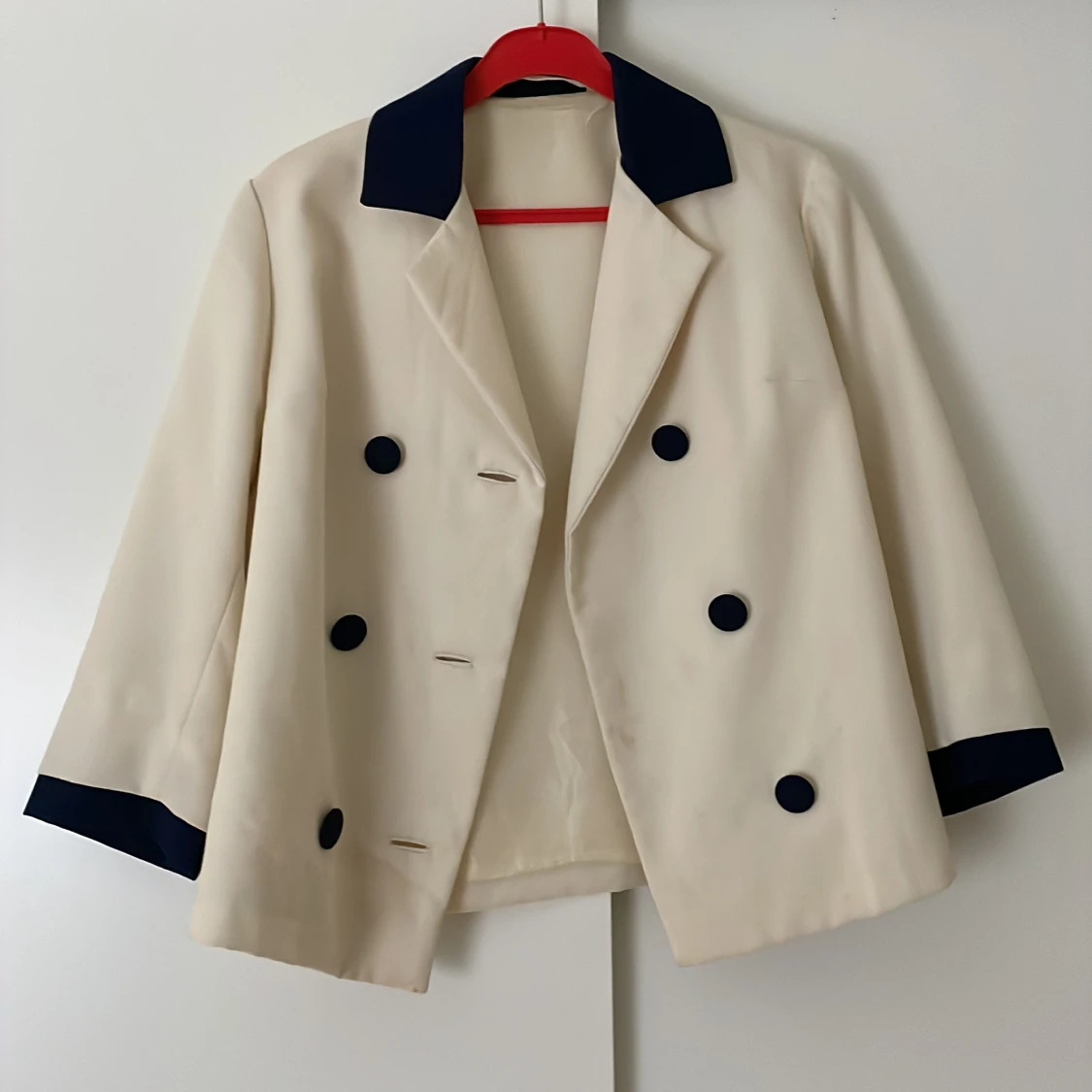 Vit kavaj med blå detaljer