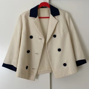 Vit kavaj med blå detaljer - Säljer en otroligt vacker fransk kavaj som tyvärr är för liten för mig. Köpt här på Sellpy men i väldigt fint skick. 