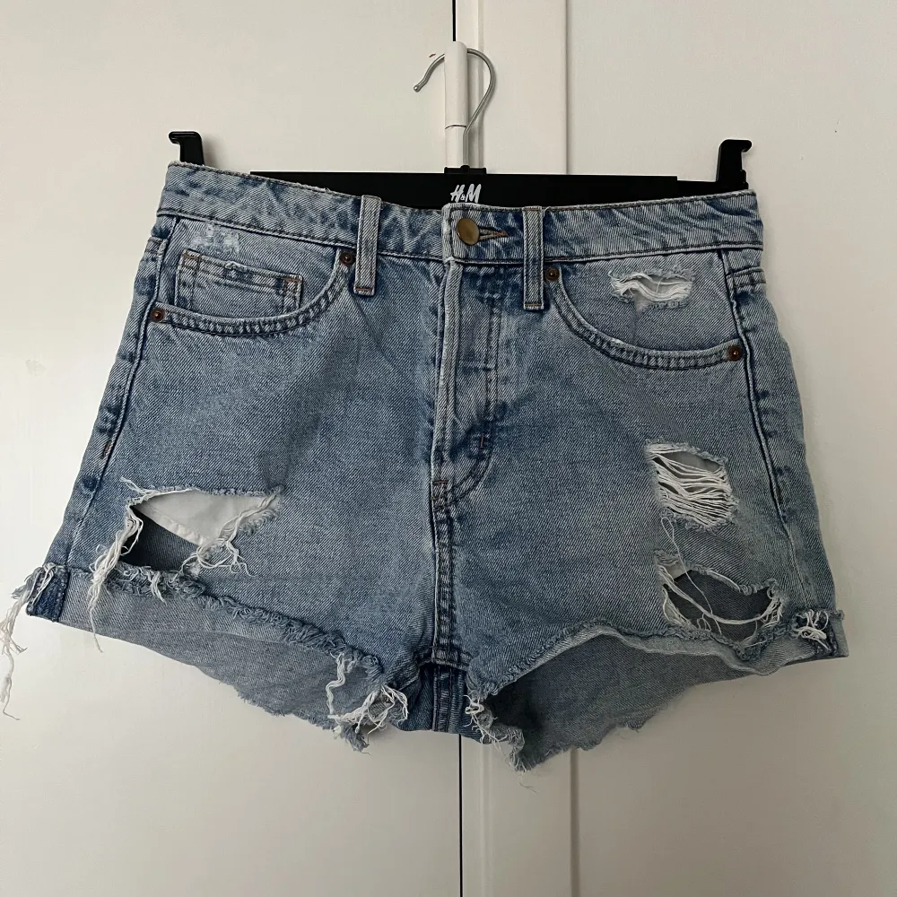 Snygga jeansshorts från H&M med slitningar och knappgylf. Säljes p.g.a för små för mig😊. Shorts.