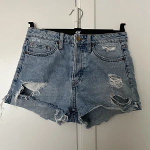 Jeansshorts  - Snygga jeansshorts från H&M med slitningar och knappgylf. Säljes p.g.a för små för mig😊