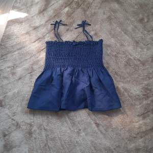 Marinblått linne liknande en kjol med rosetter på axlarna strl 12/13 yr men passar xs-s och m även l med mindre byst