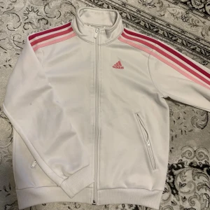 Adidas zip up  - vit Adidas zip up med rosa detaljer. perfekt att ha en sommarkväll!! storlek S men sitter mer som en XS💕. kontakta för fler bilder, mått eller frågor!💗 