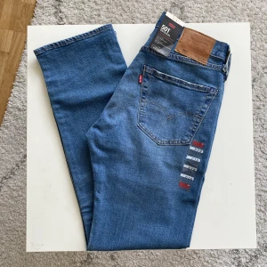 Levi’s 501 Jeans (Nyskick med lappar) - Levi’s 501 Herrjeans i nyskick med alla lappar på. Snäppet mjukare, tunnare och bekvämare i tyget än vanliga 501:or.  94% Bomull, 5% Polyester och 1% Elastan/Stretch. Midjemått: 39 cm Innerbenslängd: 78 cm