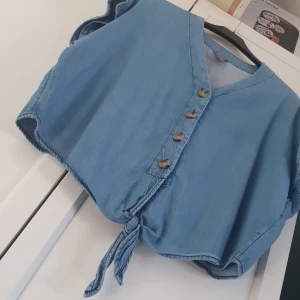 Blus i mjukt jeanstyg - Mjuk, somrig blus i jeanstyg. Aldrig använd. Djur- och rökfritt hem. Knytblus. 