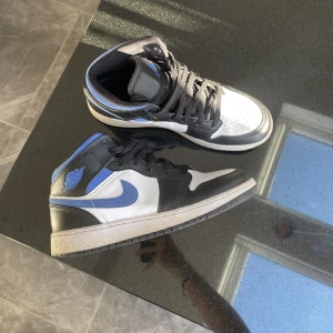 Blåa jordans - Säljer ett par blåa Jordan air 1 mid skor i storlek 38,5. De är inköpta för 1 600kr och är använda ett fåtal gånger. Skorna har inga defekter och är i ett väldigt bra skick. Säljer de för 700 +frakt😊