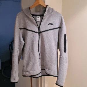 Grå Nike Tech fleece - En grå Nike Tech fleece i storlek medium. Tröjan är i mycket bra skick och har bara använts ett par gånger. Den är riktig.