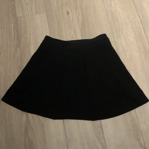 Svart Kjol - Den ser väldigt bred ut på bilden men den sitter fint på kroppen. Frakt adderas på det nuvarande priser