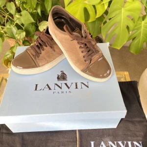 Lanvin Patent Cap Toe Sneaker Brun - Hej, säljer ett par fräscha Lanvin sneakers i Size 5 vilket motsvarar ca 40/40,5. Ljusbrun färg perfekt inför sommaren. Både mockan och toebag är i utmärkt skick. Dustbag medkommer. Nypris runt 4000kr. Pris inte hugget i sten. Hör av dig vid intresse!
