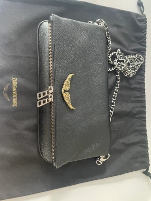 Zadig Voltaire väska - Säljer min Zadig Voltaire väska medium då den ej kommer till användning. Unik då den har ett guldigt märke. Original tyg påse och båda längderna på banden följer med. 