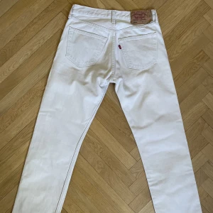 Levis 501 - Ett par riktigt fina Levis 501 i en krämvit färg. Byxorna är vintage men i fint skick utan några hål eller större fläckar. Storleken på tagen är 31/34 men byxorna är upplagda. Måtten är: W 37,5cm (mätt rakt över) L 101cm (Mätt från midja till benslut)