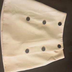 Superfin kortkjol med knappar  - Använd en gång. Strl 34. Från ASOS. 