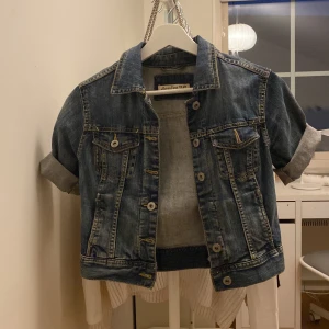 Kortärmad jeansjacka - Cool jeans jacka avklippt till kortärmad, en knapp har lossnat men följer med så att man kan laga den.