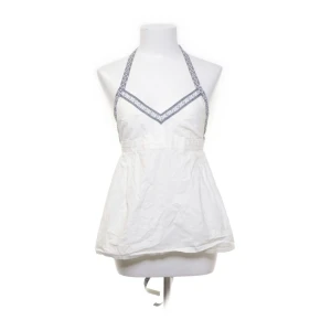 Vitt line volang  - Vit tröja med volang. Blått mönster. Knyt där bak. 