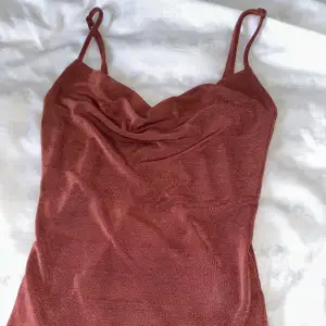 Superfint linne i storlek XS från Gina tricot. Rödrosa/rostfärgad med lite glitter. Har jättefin urringning 