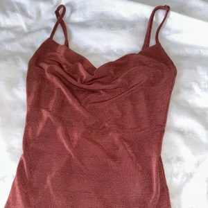 Linne glitter  - Superfint linne i storlek XS från Gina tricot. Rödrosa/rostfärgad med lite glitter. Har jättefin urringning 