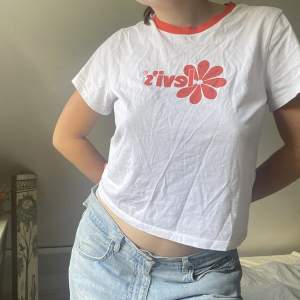 Säljer en supersnygg tshirt från levis, där l:et är omringat av en orange blomma. 