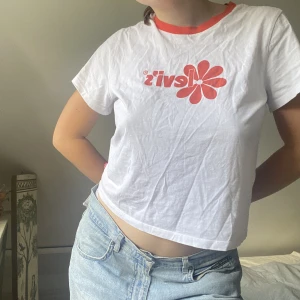 Orange levis tshirt - Säljer en supersnygg tshirt från levis, där l:et är omringat av en orange blomma. 
