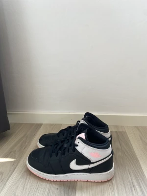Jordan 1 Mid Artic Pink Black (GS) - Använt i fint skick   Finns ingen box till skorna. 