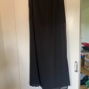 Långkjol med kort underkjol  - Långkjol som är något genomskinlig och med kort underkjol undertill. Lite festivalstil. Med stretch. I fint skick! Köpare står för frakt