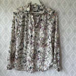 Söt mönstrad blus H&M storlek 36 - Söt blus med blommor och fåglar. Storlek 36. Använd några gånger, fint skick!
