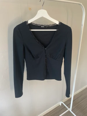 Bikbok topp - Jättegullig topp ifrån bikbok. Knappar där fram och spets runt halsen. Passar till allt. Inte använd mycket.