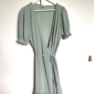 Sommarklänning  - Supersöt sommarklänning som tyvärr inte kommer till användning längre. Med omlott och volanger längst nedtill. Är i toppenskick 😊