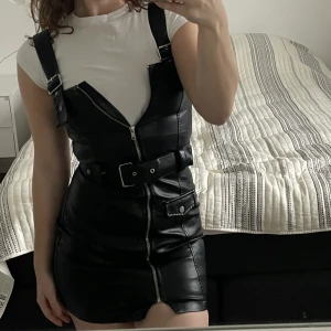 Hängselklänning från H&M - Hängselklänning i PU material (fake skinn). Endast använd vid ett tillfälle inför halloween 