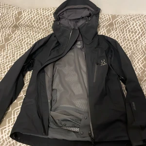 Haglöfs jacka - En Haglöfs jacka som passar perfekt till en regnig och blåsig vår. Den är i väldigt bra skick, inga hål eller slitet tyg. Har ej använts mycket innan. Pris kan också diskuteras.