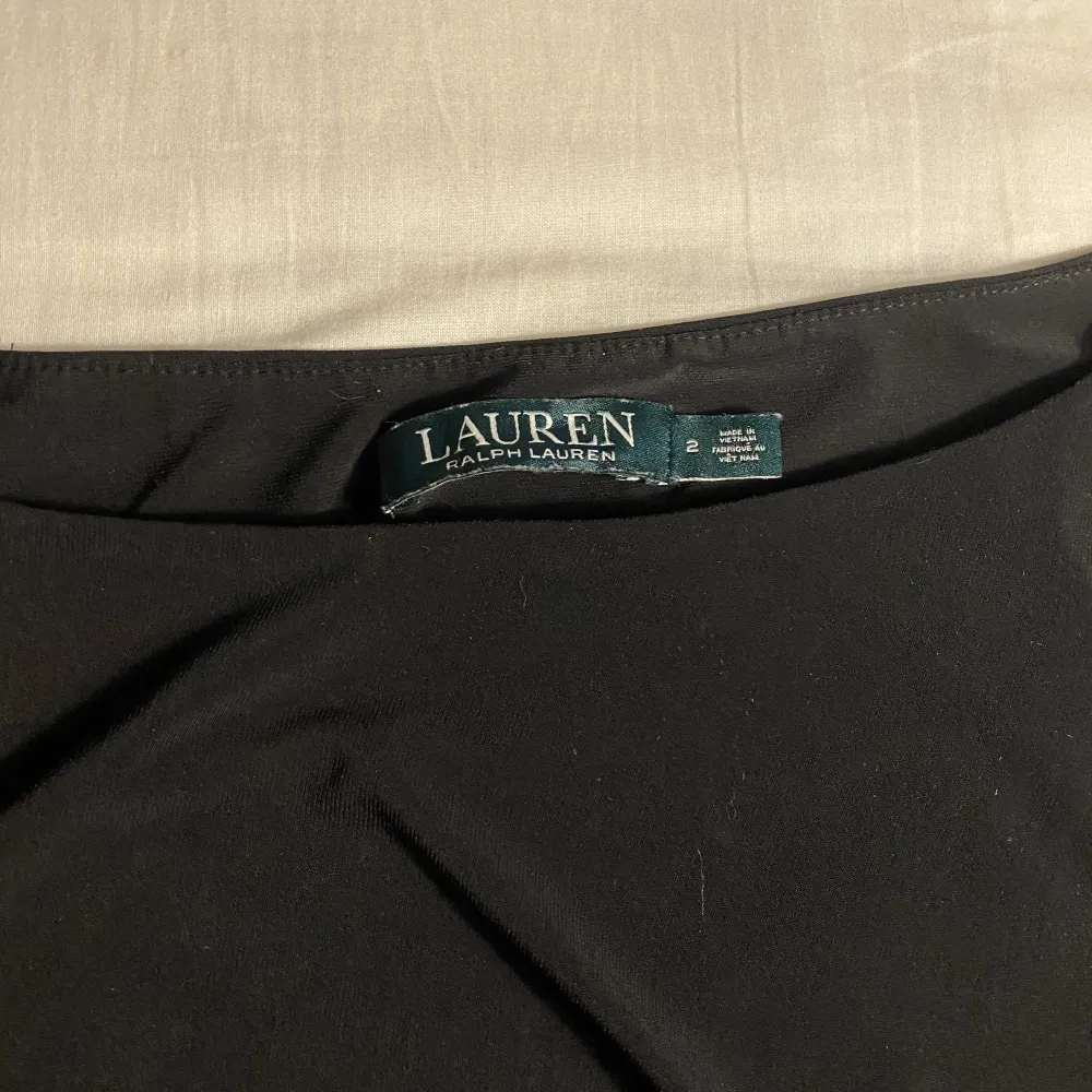 Klänning från Ralph Lauren i Polyester vilket innebär att strykning ej behövs. Draperad vid midjan vilket ger en figursydd look. . Klänningar.