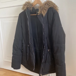 Svart jacka med pälshuva - En svart jacka storlek S/M, till vintern eller hösten