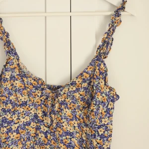 Blommig klänning  - Sparsamt använd, slits fram. Sitter så fint på men används tyvärr inte. Skulle säga att den är liten i storlek. Så mer som en s.