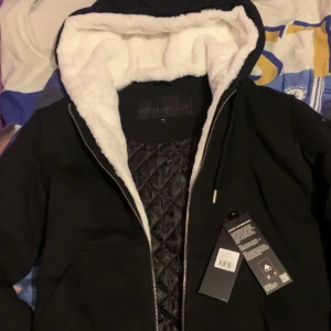 Moose Knuckles Kofta  -  Moose knuckles  logo-plaque zip-up hoodie Storlek M Är i mycket bra använt skick Köpt i U&M i väla i Helsingborg  Tagg finns och påse som bevis att den är köpt från UM  Sedan har den också QR-kod som visar om den är äkta och vilken order