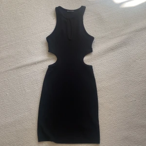 Klänning - Klänning från bershka med så fina detaljer, materialet är ribbat. Storlek XS. Endast använd en gång.💕💕 Köparen står för frakt!