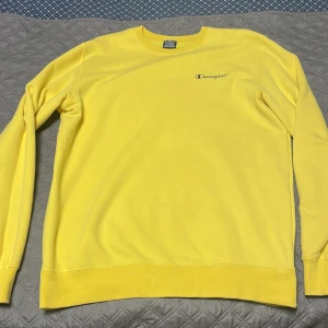 Gul champion tröja - En superbekväm gul champion tröja, text i svart och logga på ärmen. använd 2 gånger.