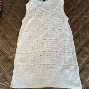 Stickad klänning - En vit stickad klänning som man kan ha på sig över en skjorta även en vanlig tröja!