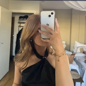 Svart satinklänning - Kort klänning med fin detalj i halsen och två pärlor som hänger ner över ryggen på varsin guldkedja💕Aldrig använd och lappen sitter kvar💕